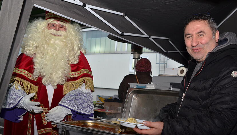 Auch der Nikolaus bekommt von Cem Kara vor dem Secondhand-Kaufhaus der Aufbauhilfe eine Portion Gulasch mit Spätzle, schließlich hat er Geschenke für Kinder im Gepäck.   
Foto: Stefanie Pfäffle