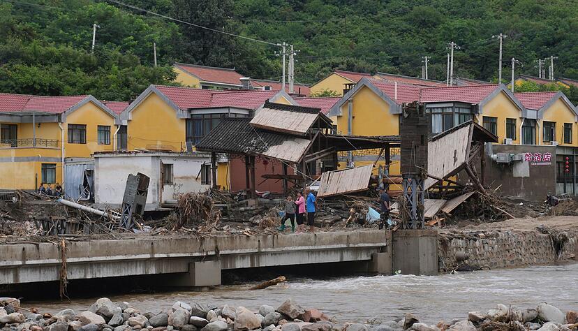 Dorfbewohner versammeln sich in der N&auml;he einer Br&uuml;cke, die nach schweren Regenf&auml;llen im Bezirk Miyun am Stadtrand von Peking &uuml;berflutet wurde.