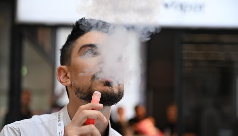 Ein Verk&auml;ufer einer E-Zigaretten-Firma nutzt bei der Dortmunder Messe Intertabac demonstrativ eine E-Zigarette. Der Verkauf dieser Produkte boomt. (Archivbild)