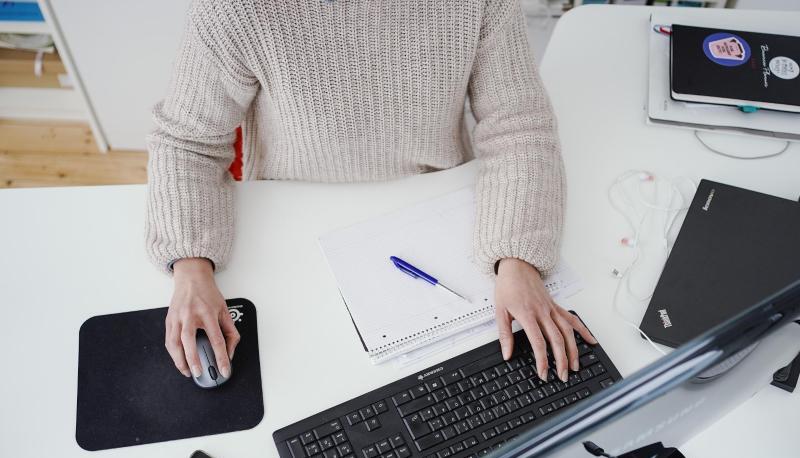 Eine Frau arbeitet in ihrer Wohnung vor einem Computer an einem Stehtisch. (Symbolbild).