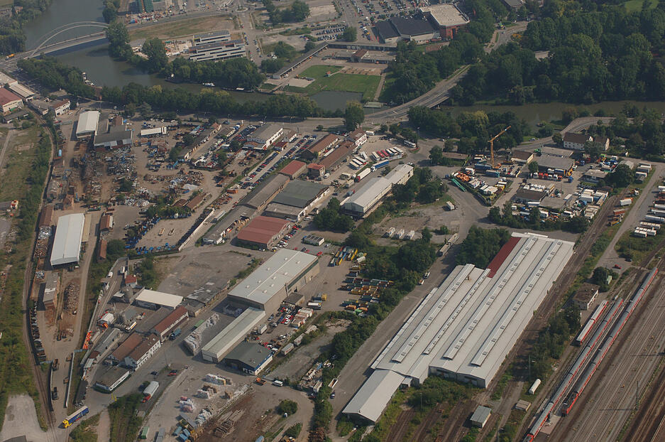 Luftaufnahme des Heilbronner Fruchtschuppenareals im September 2005. Links im Hintergrund ist die Karl-Nägele-Brücke sichtbar, zentral ein Blick auf die angesiedelten Unternehmen. Der Verkehr führt über die Kalistraße, zur Bleichinselbrücke in die Innenstadt.