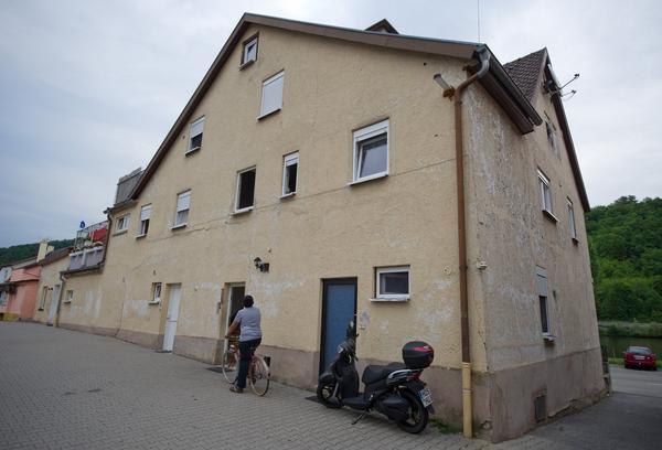 Ein Junge auf einem Fahrrad steht am Donnerstag in Haßmersheim vor einem Haus, in dem eine 20-Jährige ein Jahr lang wie eine Sklavin gefangen gehalten und sexuell genötigt worden sein soll.