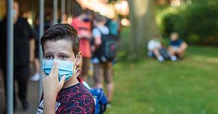Masken prägen bundesweit die Schulhöfe: Ein Schüler einer sechsten Klasse rückt an seinem ersten Schultag nach den Sommerferien an der Max-Planck-Schule in Kiel seine Maske zurecht. Foto: Gregor Fischer/dpa Masken prägen bundesweit die Schulhöfe: Ein Schüler einer sechsten Klasse rückt an seinem ersten Schultag nach den Sommerferien an der Max-Planck-Schule in Kiel seine Maske zurecht. Foto: Gregor Fischer/dpa