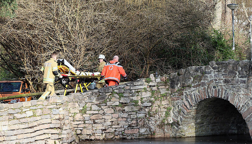 Rettungskräfte gehen in der Nähe eines Tatortes eine kleine Brücke hinauf. Rettungskräfte gehen in der Nähe eines Tatortes eine kleine Brücke hinauf.