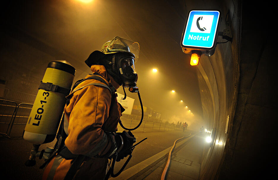 Wenn es im Tunnel brennt, werden die Fahrbahnen sofort gesperrt. Etwa einmal im Jahr kommt das vor. Die Einsatzkräfte bereiten sich auf solche Szenarien vor. Das Bild zeigt einen Feuerwehrmann bei einer Katastrophenschutzübung 2012. Bei der Übung wurde das Vorgehen bei einem Unfall mit rund 60 Fahrzeugen, Bränden und vielen Verletzten trainiert. Nach dem Umbau wird es vor den Tunneleingängen auch Schranken geben. Bislang erfolgt die Sperrung lediglich durch Lichtsignale. Wenn es im Tunnel brennt, werden die Fahrbahnen sofort gesperrt. Etwa einmal im Jahr kommt das vor. Die Einsatzkräfte bereiten sich auf solche Szenarien vor. Das Bild zeigt einen Feuerwehrmann bei einer Katastrophenschutzübung 2012. Bei der Übung wurde das Vorgehen bei einem Unfall mit rund 60 Fahrzeugen, Bränden und vielen Verletzten trainiert. Nach dem Umbau wird es vor den Tunneleingängen auch Schranken geben. Bislang erfolgt die Sperrung lediglich durch Lichtsignale.