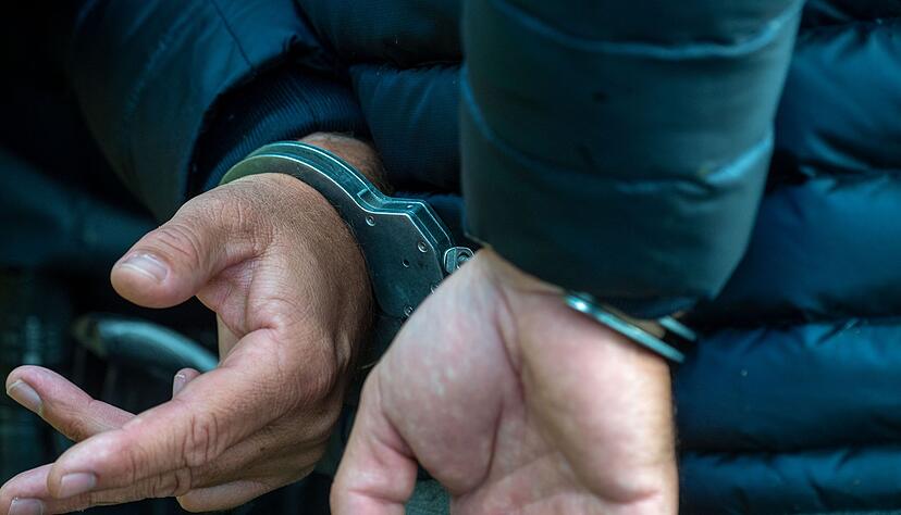 Ein Mann trägt Handschellen.