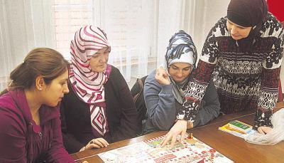 Dozentin Anja K&ouml;rner-Bennis erkl&auml;rt den Frauen das Einkaufsspiel, mit dem allt&auml;gliche Lebensmittelbegriffe spielerisch ins Ged&auml;chtnis r&uuml;cken.Foto: Stefanie Pf&auml;ffle