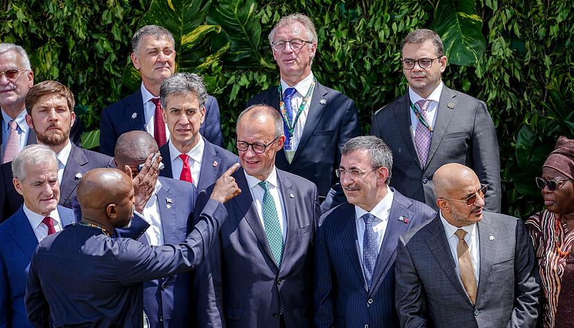 Merz stellt sich zum Familienfoto auf der COP30 auf.