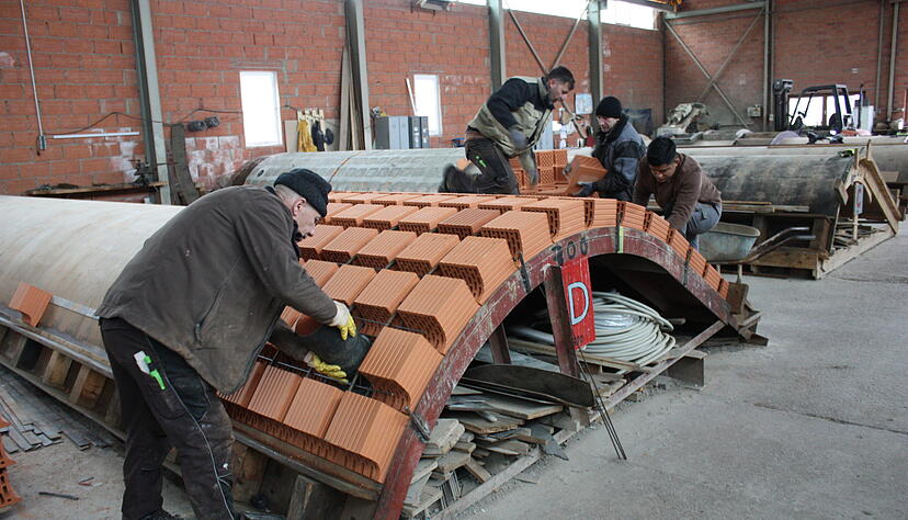 In der Montagehalle werden Ziegel zu einem Fertiggew&ouml;lbe aufgereiht.