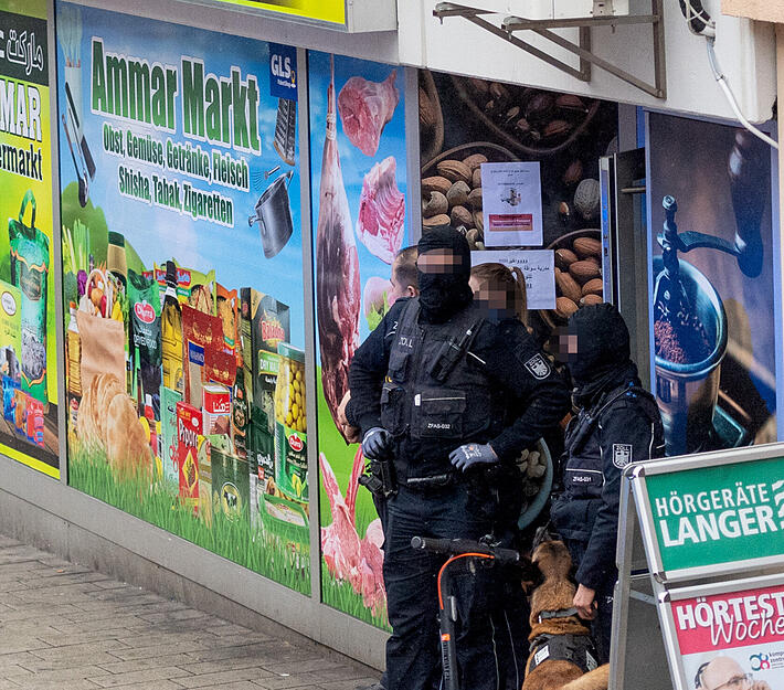 Beamte sichern den Eingangsbereich des Supermarkts in der Heilbronner Innenstadt ab.