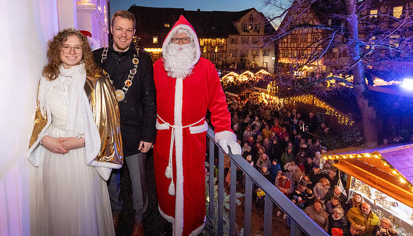Bürgermeister Andreas Zaffran, eingerahmt von Christkind und Nikolaus, bei der Eröffnung des Weihnachtsmarkts in Bad Wimpfen.