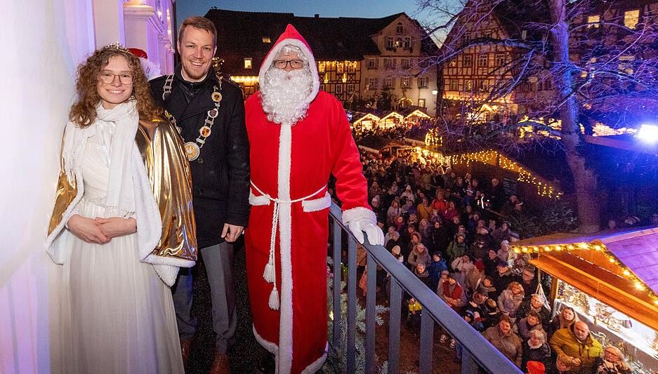 Bürgermeister Andreas Zaffran, eingerahmt von Christkind und Nikolaus, bei der Eröffnung des Weihnachtsmarkts in Bad Wimpfen.