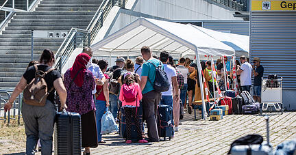 Reiserückkehrer stehen vor dem Corona-Testzentrum am Flughafen Stuttgart. Foto: dpa