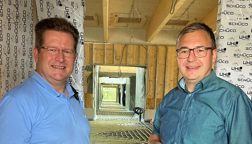 Bauherren-Vertreter Theo Rappold (links) und Massenbachhausens B&uuml;rgermeister Nico Morast am Eingang. Die auf den Estrich wartenden Leitungen f&uuml;r die Fu&szlig;bodenheizung betonen die Dimensionen des Kindergartenneubaus.