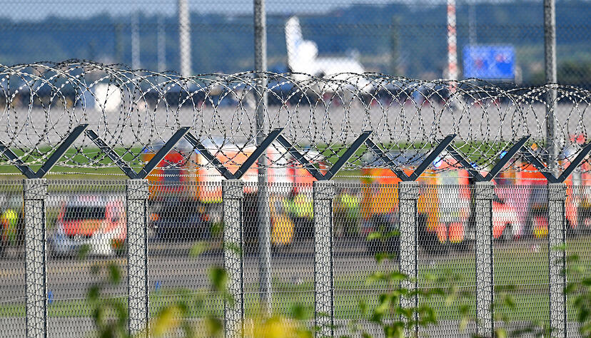 Feuerwehr- und Polizeiautos stehen auf dem Vorfeld am Stuttgarter Flughafen. Dahinter geht der Flugbetrieb weiter. Aktivisten der Klima-Initiative Letzte Generation hatten sich am Donnerstag als Protestaktion auf einer Zufahrt zu einer Start- und Landebahn festgeklebt. Feuerwehr- und Polizeiautos stehen auf dem Vorfeld am Stuttgarter Flughafen. Dahinter geht der Flugbetrieb weiter. Aktivisten der Klima-Initiative Letzte Generation hatten sich am Donnerstag als Protestaktion auf einer Zufahrt zu einer Start- und Landebahn festgeklebt.