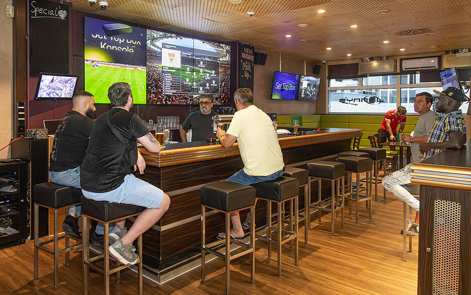 Fu&szlig;ballfans schauen den Supercup in Jonnys Sportsbar: Auch hinter dem Tresen h&auml;ngen Bildschirme.