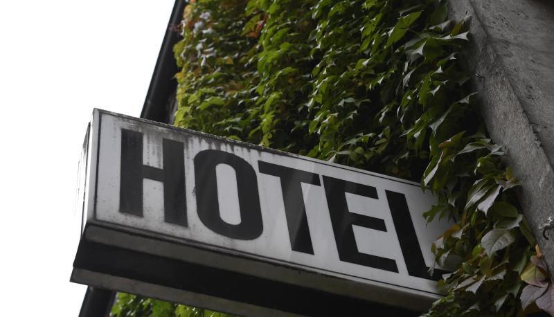 Ein Schild "Hotel" ist an der mit Efeu bewachsenden Wand eines Gebäudes angebracht.