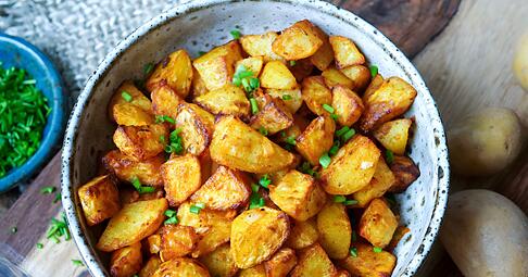 Nur kleine Mengen Fett bekommen Bratkartoffeln per Ölsprüher ab, werden mit Salz und Paprikapulver gewürzt und kommen in den Airfryer: Nach 25 Minuten sind die Kartoffelstücke richtig schön knusprig.