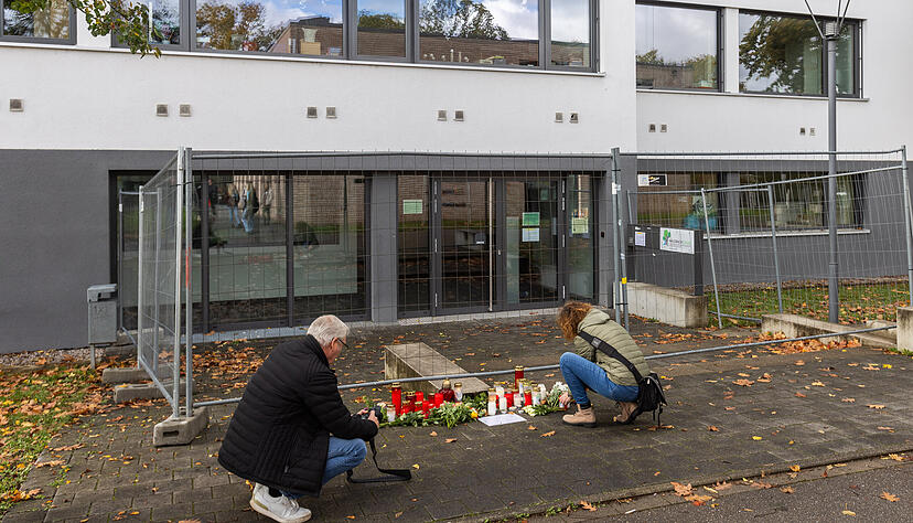 Eine Frau legt Blumen vor der Waldbachschule ab, während sie von einem Medienvertreter dabei fotografiert wird. Eine Frau legt Blumen vor der Waldbachschule ab, während sie von einem Medienvertreter dabei fotografiert wird.