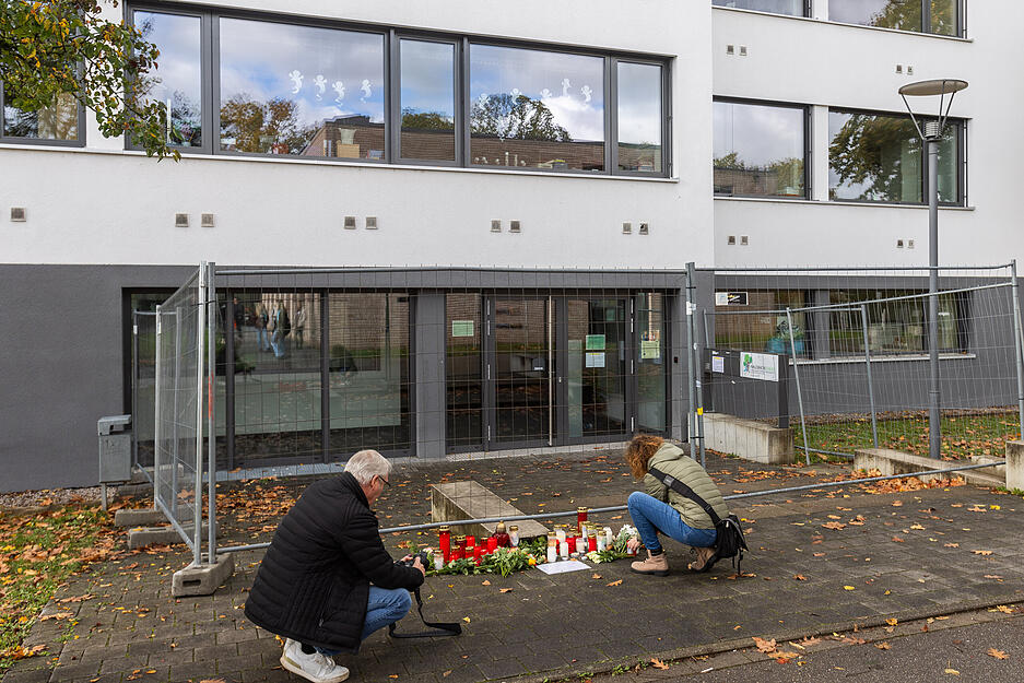 Eine Frau legt Blumen vor der Waldbachschule ab, während sie von einem Medienvertreter dabei fotografiert wird. Eine Frau legt Blumen vor der Waldbachschule ab, während sie von einem Medienvertreter dabei fotografiert wird.
