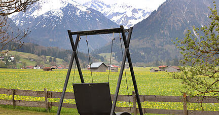 Eine leere Schaukel mit Bergblick steht im Au&szlig;enbereich eines Hotels. Pfingsturlaub in Bayern? Foto: Dpa
