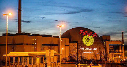 Bei einer Greenpeace-Aktion gegen Atomkraft haben Aktivisten mit Hilfe eines großen Projektors symbolisch eine abgelaufene HU-Plakette und die Wörter «abschalten!», sowie «Abgelaufen» auf das Kernkraftwerk Neckarwestheim projiziert.