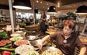 Merle Fehr bereitet eine Gem&uuml;sepfanne vor. Im Hintergrund schnippelt Chantal Kundorf Gem&uuml;se. Das alles geschieht vor den Augen der G&auml;ste.