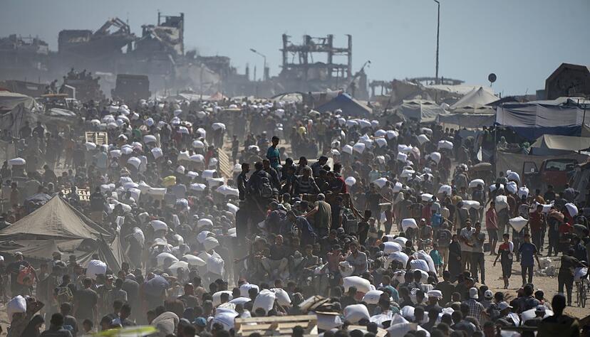 Pal&auml;stinenser tragen S&auml;cke mit Mehl aus einem Hilfskonvoi. (Archivbild)
