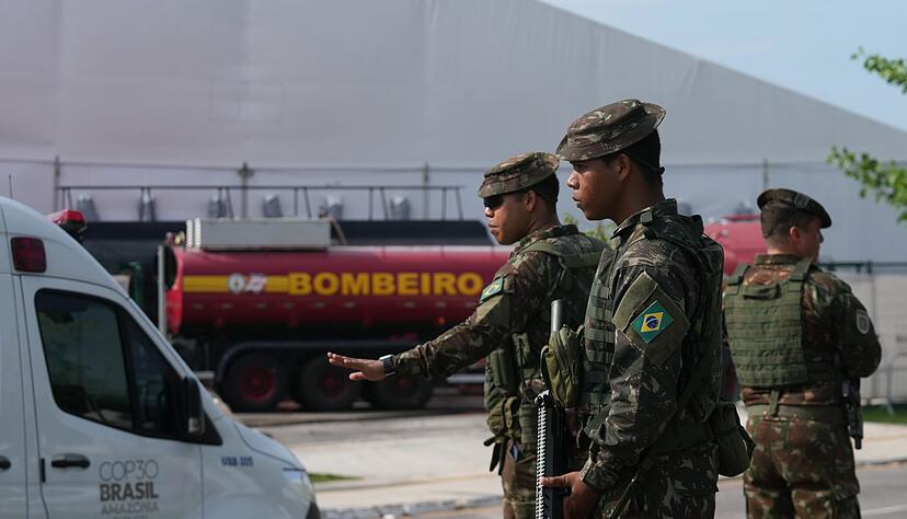 Sicherheitskräfte leiten Fahrzeuge nach einem Brand auf dem Gelände der Weltklimakonferenz. Sicherheitskräfte leiten Fahrzeuge nach einem Brand auf dem Gelände der Weltklimakonferenz.