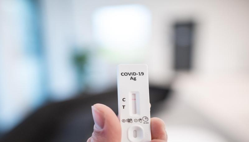 Ein Mann h&auml;lt einen Corona-Schnelltest in der Hand.