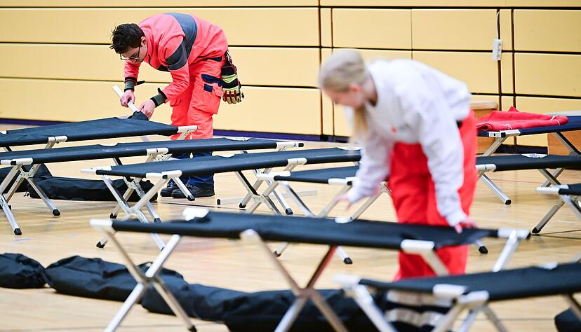 0Ehrenamtliche Mitarbeiter des DRK bauen während eines Stromausfalls im Südwesten Berlins in einer Notunterkunft Feldbetten auf. 0Ehrenamtliche Mitarbeiter des DRK bauen während eines Stromausfalls im Südwesten Berlins in einer Notunterkunft Feldbetten auf.