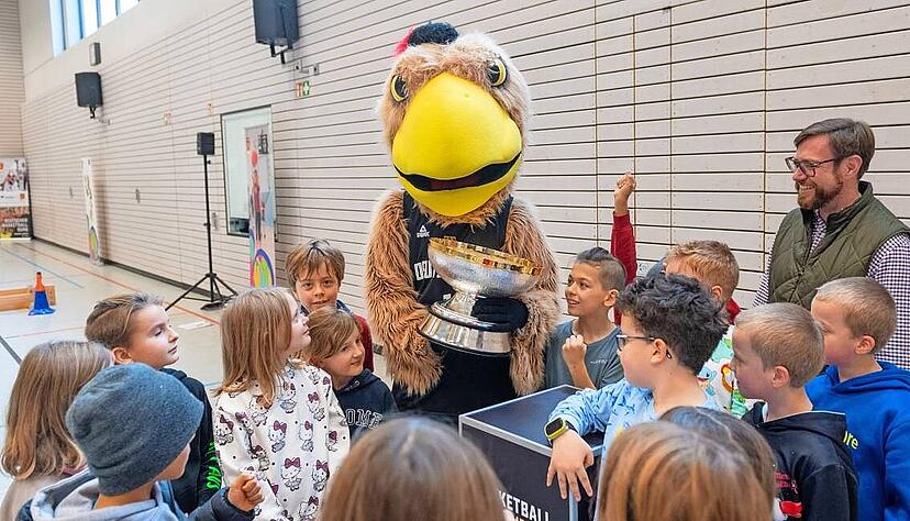 Ganz nah kommen die Drittkl&auml;ssler der Georg-Kropp-Schule dem funkelnden EM-Pokal. F&uuml;r nicht weniger Begeisterung sorgt Maskottchen Arnold (Mitte).