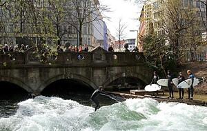 Die Eisbachwelle gilt als beliebter Hotspot für Surfer, Zuschauer und Fotografen. Sie liegt am südlichen Rand des Englischen Gartens in München. Die Eisbachwelle gilt als beliebter Hotspot für Surfer, Zuschauer und Fotografen. Sie liegt am südlichen Rand des Englischen Gartens in München.