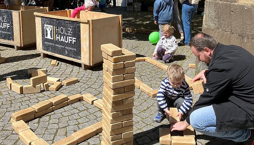 Unterm Lindenbaum an der Stiftskirche werden T&uuml;rme aus Holzkl&ouml;tzen gebaut.