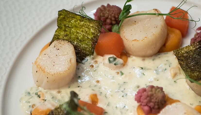 Alexis Tison bereitet die Jakobsmuscheln auf S&uuml;&szlig;kartoffelp&uuml;ree und mit einer Creme-Fraiche-Sauce zu.