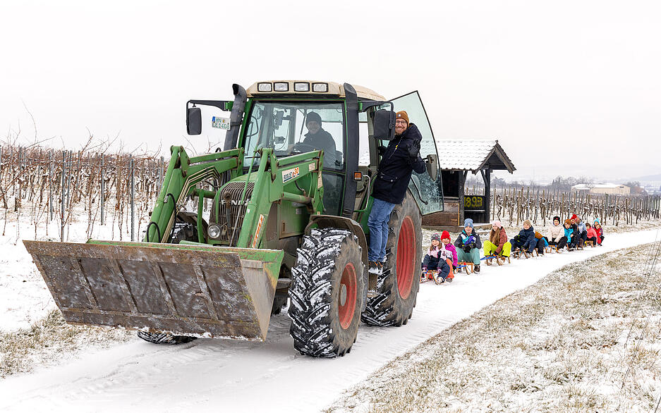 Ein Traktor zieht Kinder hinter sich her &ndash; so geht es deutlich leichter wieder hoch.