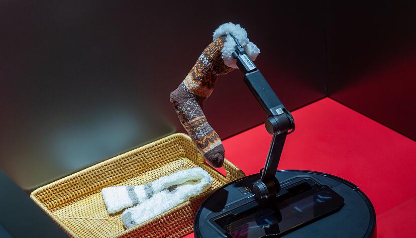 Selbst aufr&auml;umen war gestern: Der Roboter-Staubsauger Saros Z70 von Roborock demonstriert auf der Technik-Messe CES, wie er Socken einsammeln und in einen Korb bringen kann.
