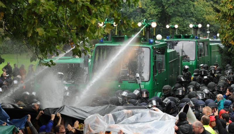 Ein Wasserwerfer spritzt im Schlossgarten Stuttgart auf Demonstranten.