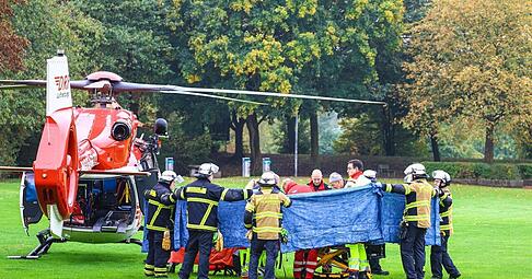 Einsatzkräfte stehen neben einem Rettungshubschrauber. Die neu gewählte Bürgermeisterin von Herdecke, Iris Stalzer (SPD), ist lebensgefährlich verletzt worden.