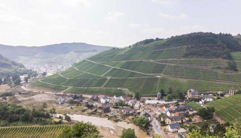 Der Fluss Ahr fließt durch das Ahrtal an dem zerstörten Ort Marienthal und den Weinbergen vorbei. Der Fluss Ahr fließt durch das Ahrtal an dem zerstörten Ort Marienthal und den Weinbergen vorbei.