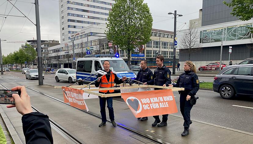 Vor dem Gerichtsprozess in Heilbronn gegen Klimaaktivisten der "Letzten Generation" ist ein Aktivist mit einem Holzkonstrukt auf der Allee unterwegs.
