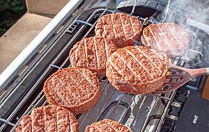 Auf dem Rost entstehen die typischen Grillstreifen, es raucht.