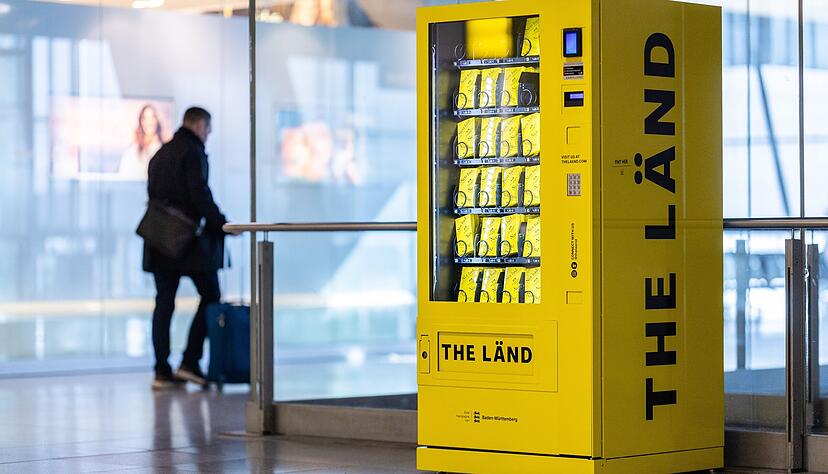 Ein Reisender geht am Stuttgarter Flughafen an einem Nett-Hier-Stickerautomat vorbei. In dem Automaten findet man die bekannten "Nett Hier. Aber waren Sie schon mal in Baden-Württemberg" Sticker. Ein Reisender geht am Stuttgarter Flughafen an einem Nett-Hier-Stickerautomat vorbei. In dem Automaten findet man die bekannten "Nett Hier. Aber waren Sie schon mal in Baden-Württemberg" Sticker.