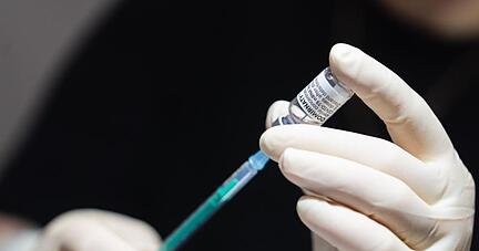 Eine Frau bereitet im Impfzentrum Coburg Spritzen mit dem Impfstoff von Biontech/Pfizer vor.