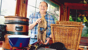 Otto Vogelmann mit einem alten Balkenrad und einem Brotkorb, den Bäcker sich auf ihren Rücken schnallten, um mit dem Rad Brezeln auszufahren.Foto: Anne Väisänen