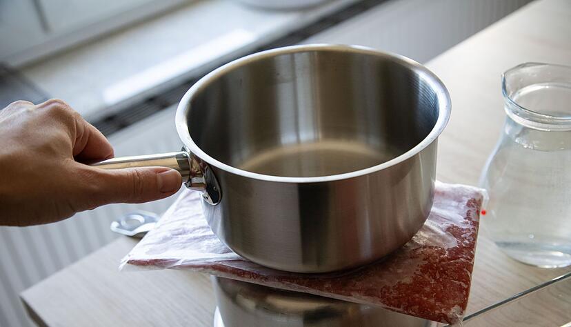 Schritt 1: Das Hackfleisch in einem Gefrierbeutel auf einen umgedrehten Topf legen, einen weiteren Topf daraufstellen.