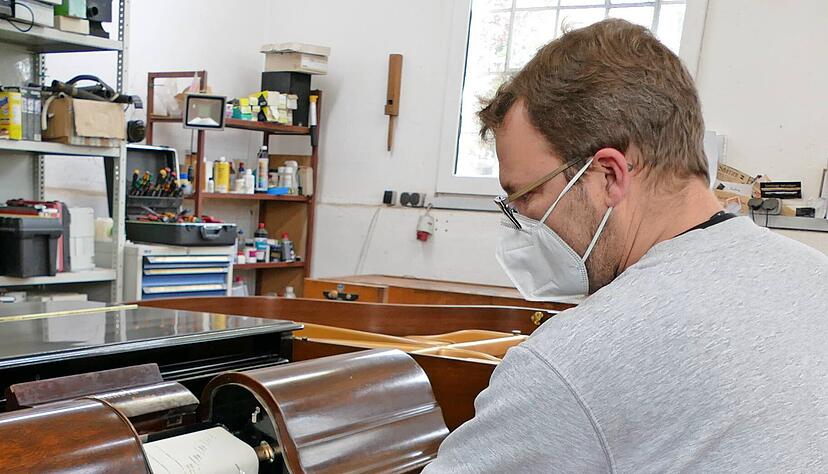 An dem musealen Pianola der Aeolian Company muss Daniel Heil noch die Pedale treten. Die Musik kommt von der Lochstreifen-Rolle.   
Foto: Helga El-Kothany