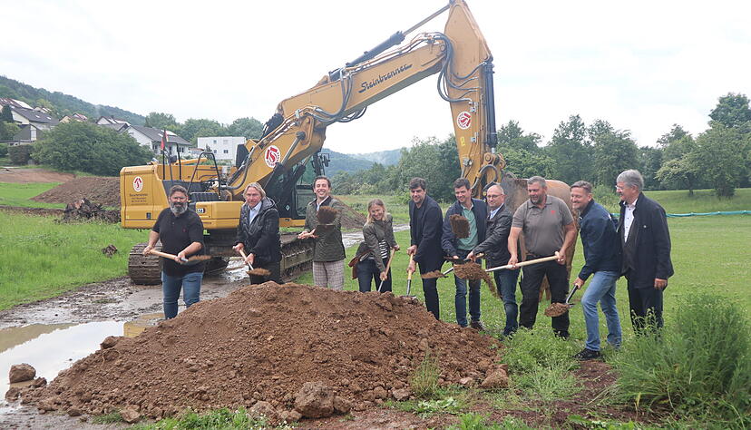 Architekten, Ingenieure, beteiligte Firmen und Verwaltung werfen beim obligatorischen Spatenstich symbolisch die Erde in die H&ouml;he.