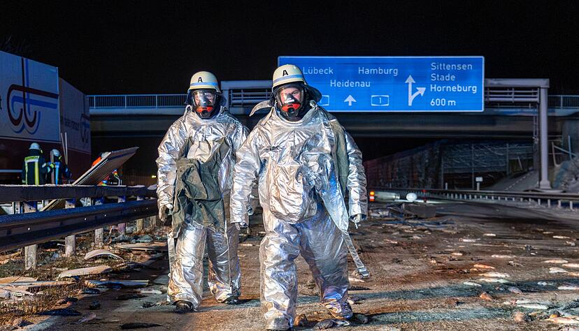 &Uuml;berall Fische auf der Fahrbahn: Bei dem Unfall auf der A1 mussten Feuerwehrleute die Unfallstelle zun&auml;chst in speziellen Schutzanz&uuml;gen sichern.