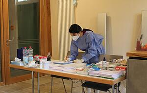 Ayse Bügümez nimmt am Eingang des Gärtnerhauses die Patienten in Empfang. Um die Sicherheit zu gewährleisten, trägt auch sie Kittel, Maske und Handschuhe. Foto: Elfi Hofmann Ayse Bügümez nimmt am Eingang des Gärtnerhauses die Patienten in Empfang. Um die Sicherheit zu gewährleisten, trägt auch sie Kittel, Maske und Handschuhe. Foto: Elfi Hofmann